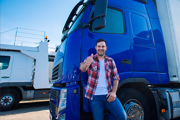 AdBlue nachfüllen – Lkw-Fahrer lehnt an seinem blauen Dieselfahrzeug